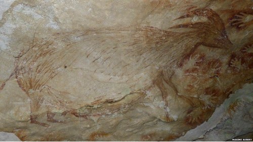 Painting of a dwarf water buffalo and stencils of human hands from a cave in SW Sulawesi (credit: Maxim Aubert, Griffith University, Australia)