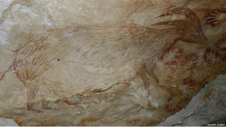 Painting of a dwarf water buffalo and stencils of human hands from a cave in SW Sulawesi (credit: Maxim Aubert, Griffith University, Australia)